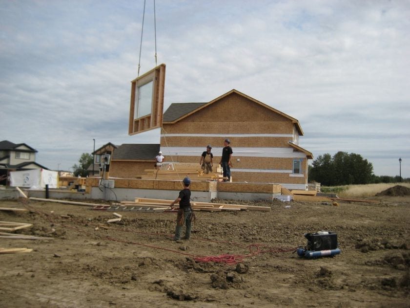 Constructions workers moving walls into place for a home under construction